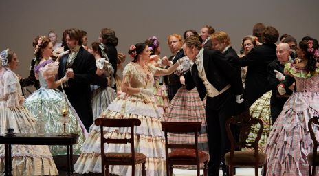 A group of people on stage wearing ballgowns and suits